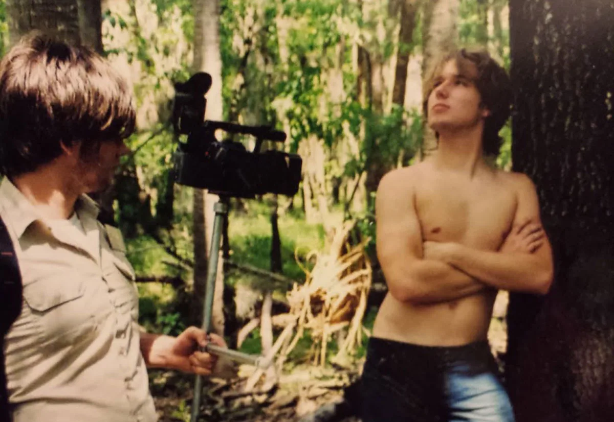 Two teenagers filming in the woods with a camcorder on a tripod, from the founders' early years